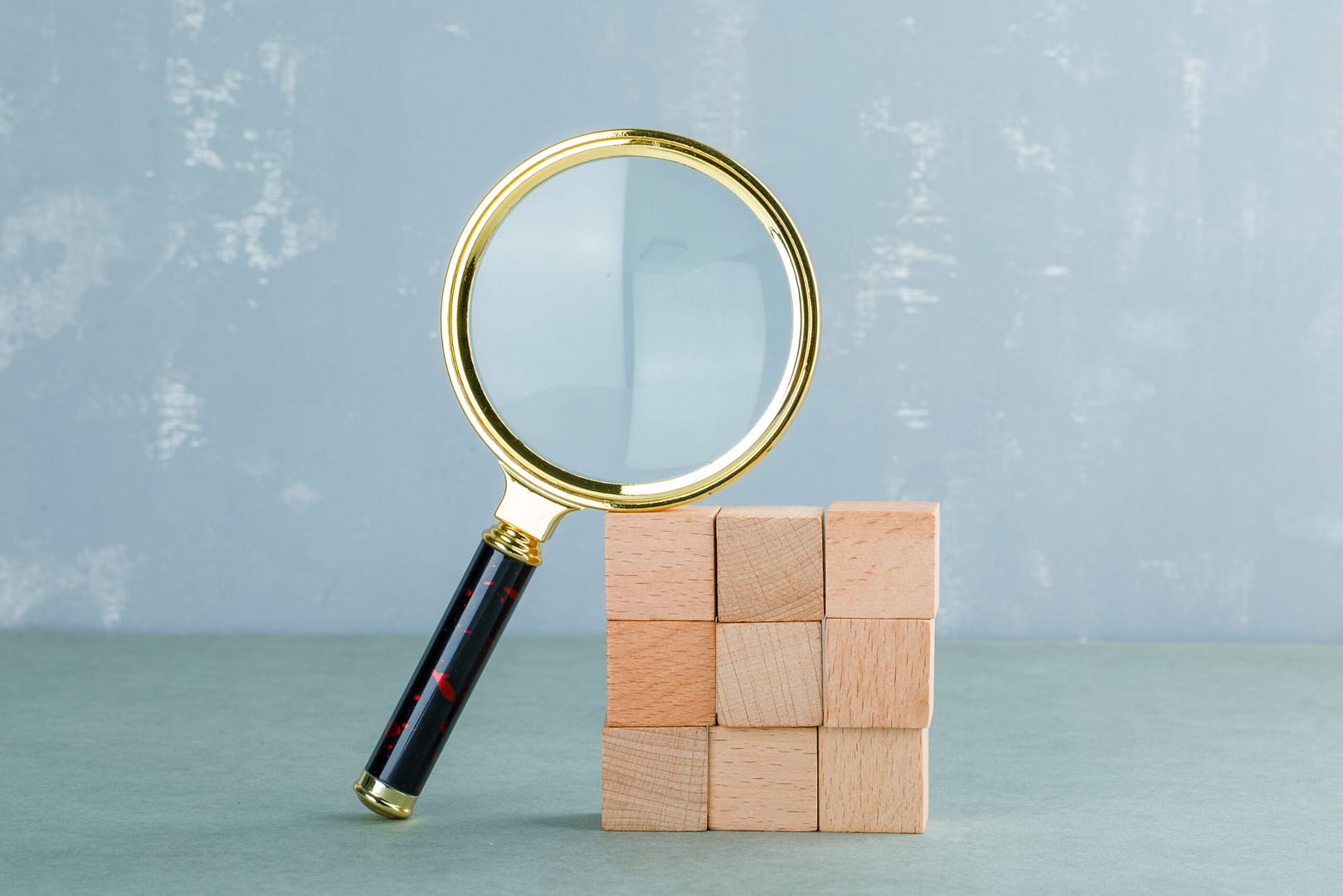 conceptual search with wooden blocks magnifying glass side view scaled